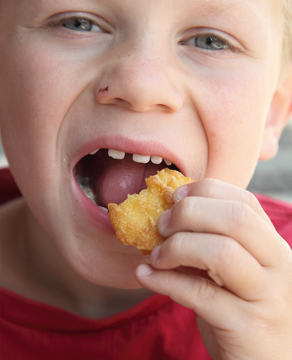 Junior worker biting a chicken nugget