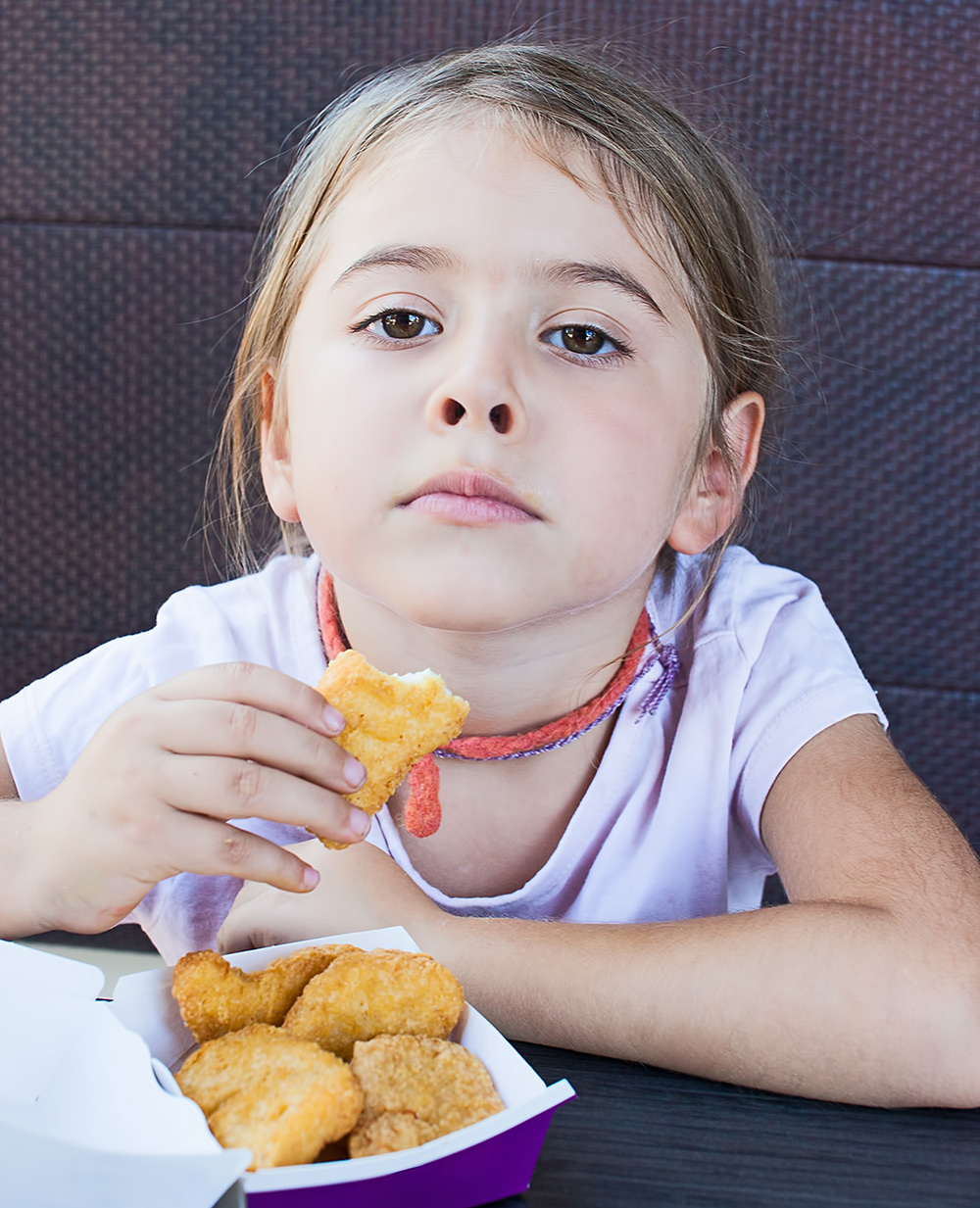 Junior worker holding a chicken nugget